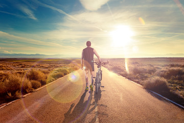 Bicicleta y aventuras, estilo de vida. Ciclista y paisaje de carretera