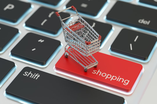 Internet shopping and online purchases concept, macro view of supermarket shopping cart on a computer keyboard