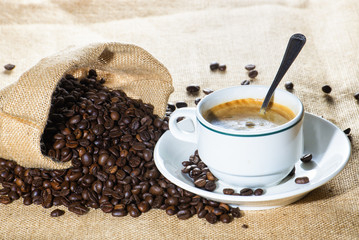 Cup of coffee and coffee beans in sack