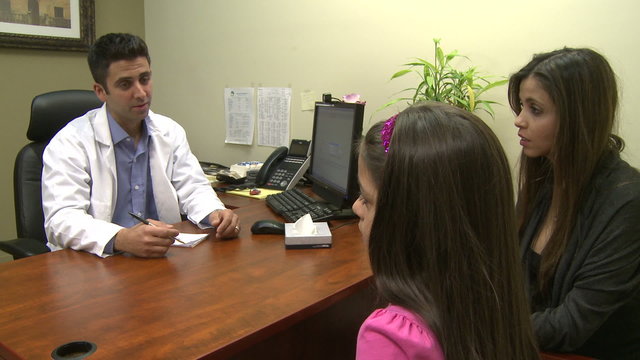 Male doctor consults with mother and daughter