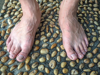 Textured cement  paved with stones and Foot Massage