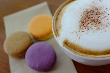 open blank old notebook and hot coffee and macaron on wooden table