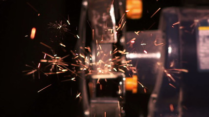 Sparks spraying towards camera from grindstone shallow depth of field
