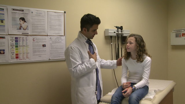 Doctor discusses symptoms with young patient
