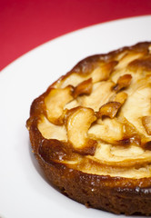 Apple pie on a white plate with red background