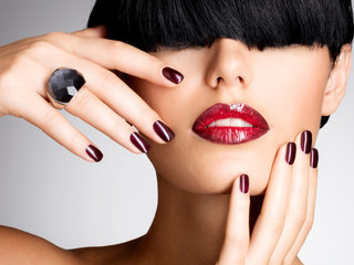 Closeup face of a woman with beautiful sexy red lips and dark na