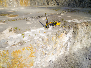 Aerial view of a drilling machine in the opencast mine. Industrial background from landscape after mining © Kletr
