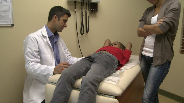 Male doctor examines sick child