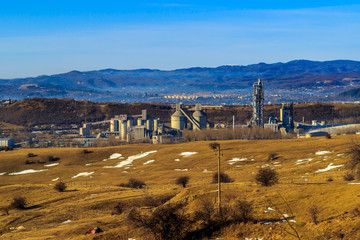 Industrial area in in the background with smoking factory chimneys, forest and mountains,