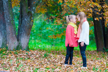 Two adorable little girls enjoying autumn sunny day