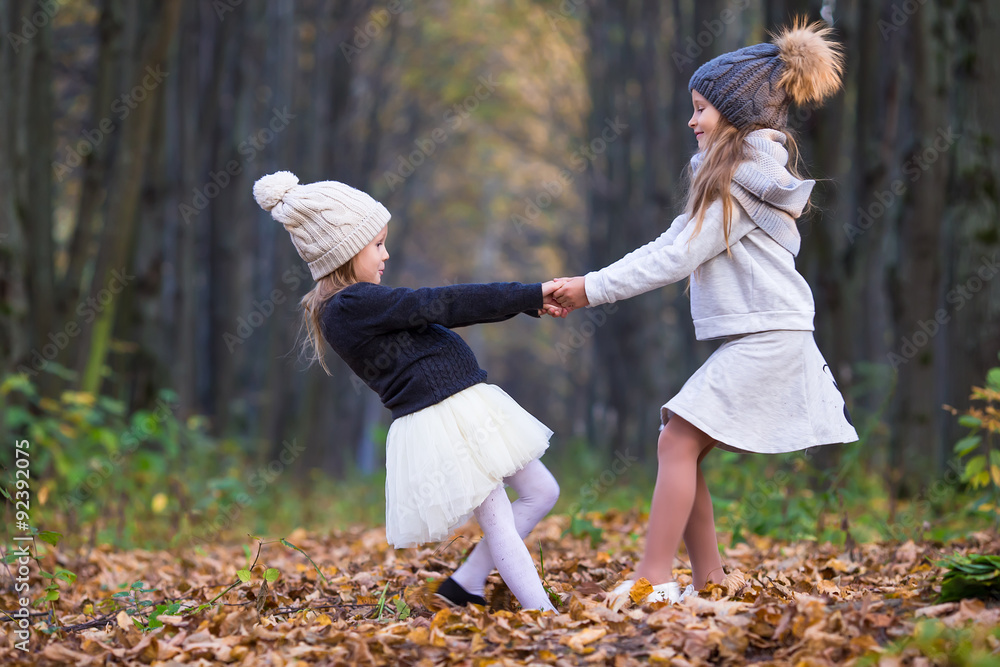 Wall mural little adorable girls outdoors at warm sunny autumn day