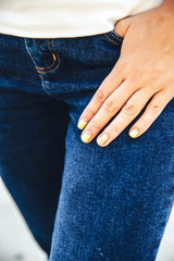 Female hand with stylish colorful nails, fashion jeans, manicure