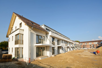 Fototapeta na wymiar Baustelle vor Fertigstellung: Neubau von modernen Wohnhäusern