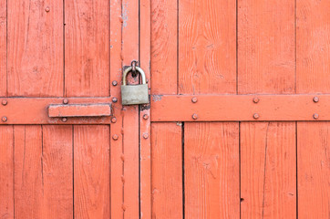 Wooden warehouse door secured with a latch and padlock
