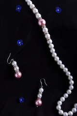 Pearls necklace and earrings on black