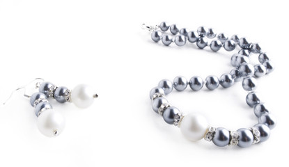 Pearls necklace and earrings on white