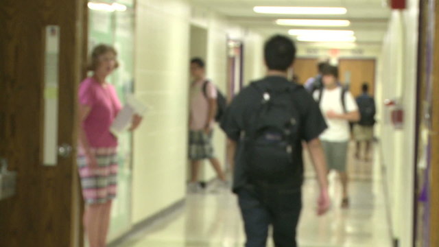 Junior high students walking down hallway 