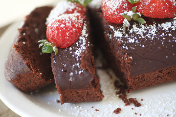 Chocolate loaf cake with fresh strawberries and powdered sugar on top