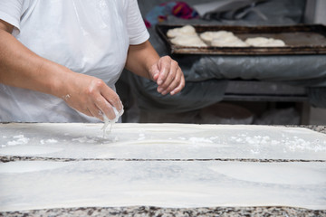 close up of female hands kneading dough and making banitsa