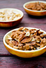 Assorted nuts in dishes on wooden table