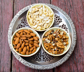 Assorted nuts in dishes on wooden table