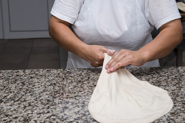 close up of female hands kneading dough and making banitsa