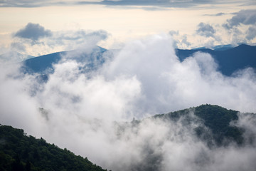 The clouds start to rise as the sun comes up over the Blue Ridge Mountains in near the Blue Ridge Parkway in North Carolina. 
