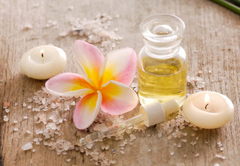 wooden background -frangipani, oil and pile of salt

