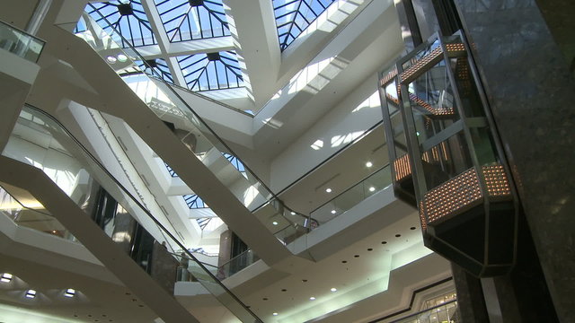 Watching elevator descend from glass ceiling within mall
