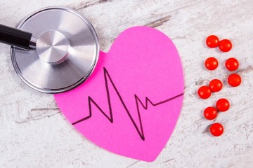 Heart of paper with cardiogram line, stethoscope and supplement pills, medicine and healthcare...