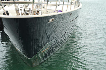 Water reflections on a shiny black hull of a luxurious yacht.