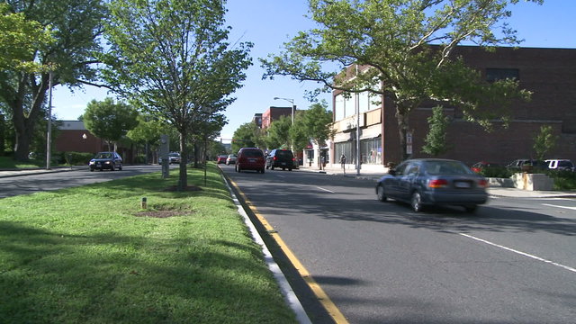 Traffic going down road with grassy median strip 