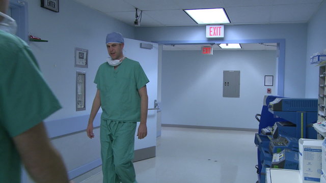 Doctors acknowledge each other in hospital hallway