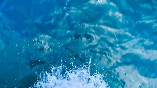 closeup foam splashes in blue sea made by high-speed motorboat