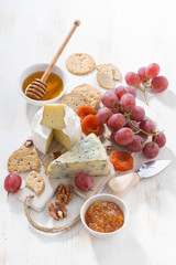molded cheeses, fruit and snacks on a white wooden board © cook_inspire