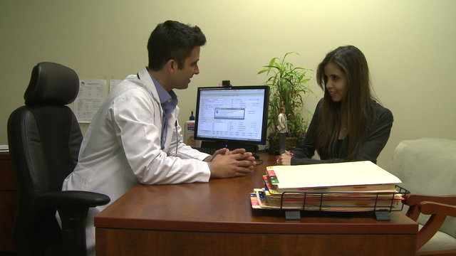 Male doctor consults with female patient