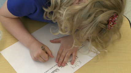 Grammar school student drawing with crayon in classroom