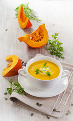 Bowl of  pumpkin soup with fresh herbs.