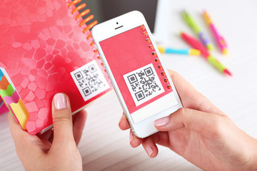 Woman scanning voucher code with mobile phone close up