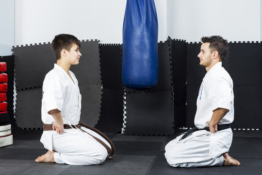 Two young men in white kimono down on their knees ready to start