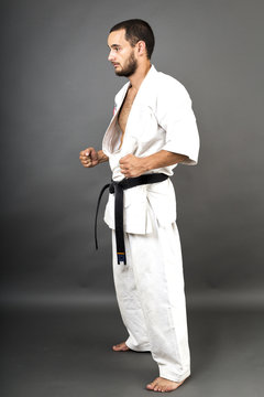 Studio shot of young man in white kimono and black belt