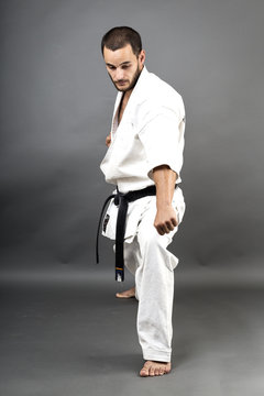 Full length portrait of young man in white kimono and black belt