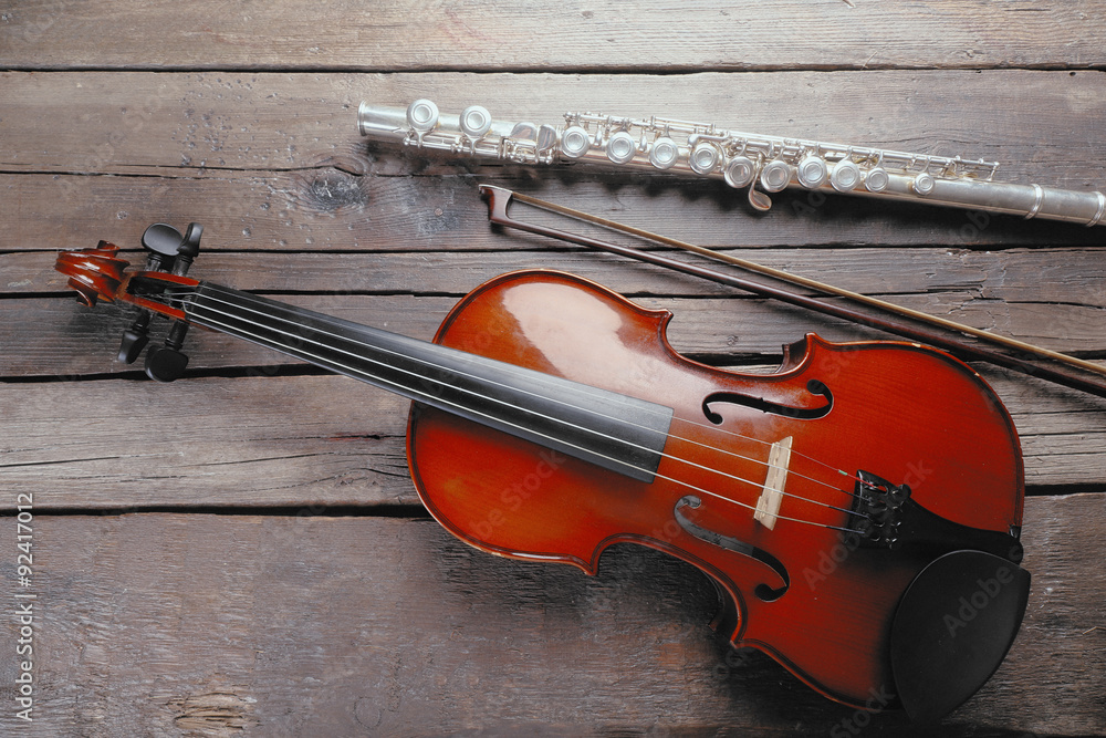 Wall mural Flute with violin on table close up