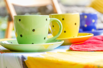 two bright tea cups set for breakfast in outdoor cafe