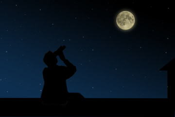 Fototapeta na wymiar The man on the roof looks through binoculars at the full moon at night