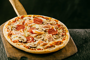 Pizza italienne fraîchement préparée avec du jambon et du salami