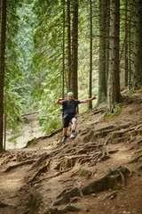 Obraz premium Man doing trail running in the forest
