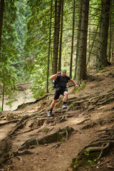 Naklejka premium Man doing trail running in the forest