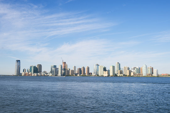 City skyline of Jersey City and Hoboken New Jersey from across the waters of the Hudson River