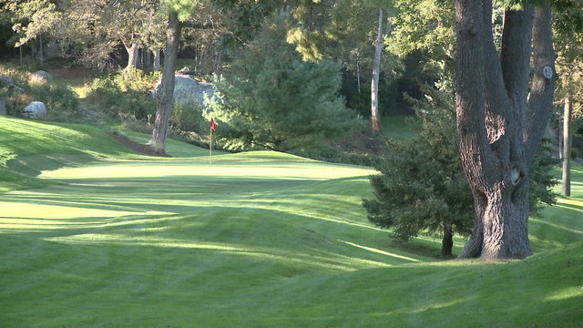 Looking across a hilly area to a putting green